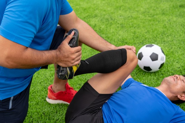 A physician helping a footballer
